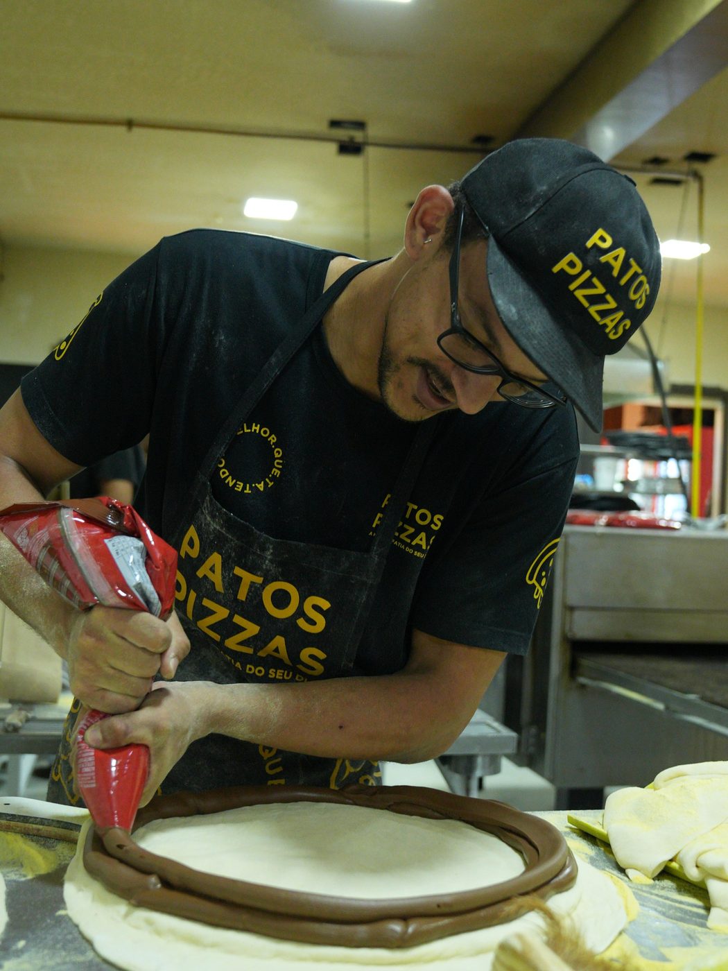 Pizzaiolo da Patos Pizzas preparando uma pizza